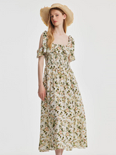 a lady in maxi floral printed dress with a straw hat
